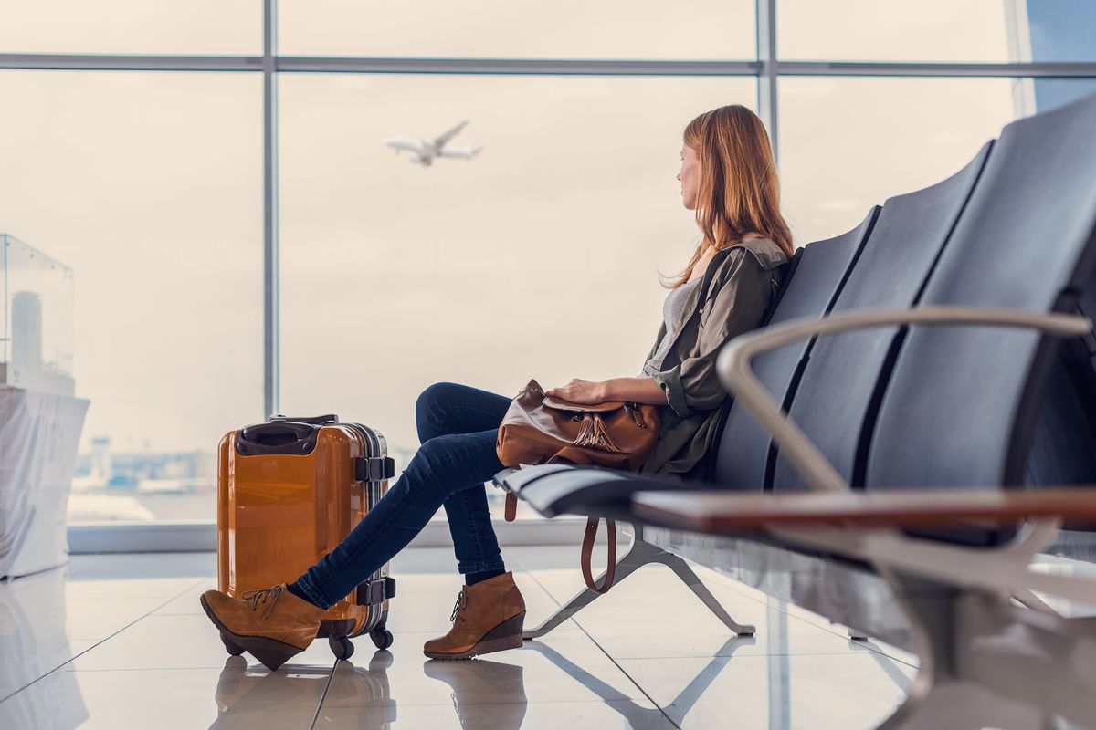 Una donna attende il volo in aeroporto