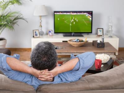 Un uomo guarda una partita in tv