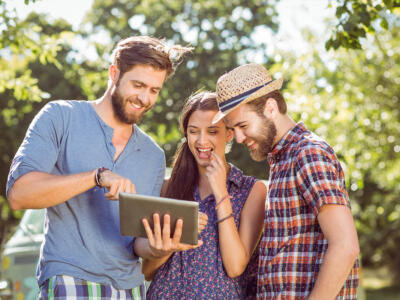 amici guardano video su tablet, all'aperto, connettività