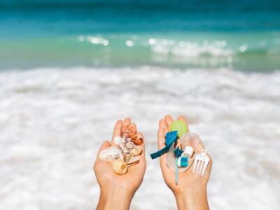 Un bambino raccoglie conchiglie e plastica dal mare