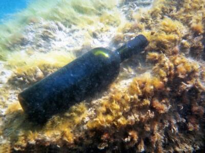 Una bottiglia di vino affinata su un fondale marino
