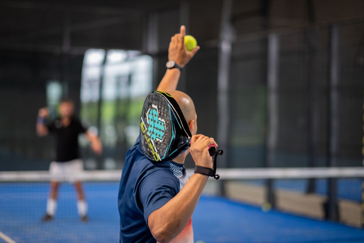 Un giocatore di padel in battuta