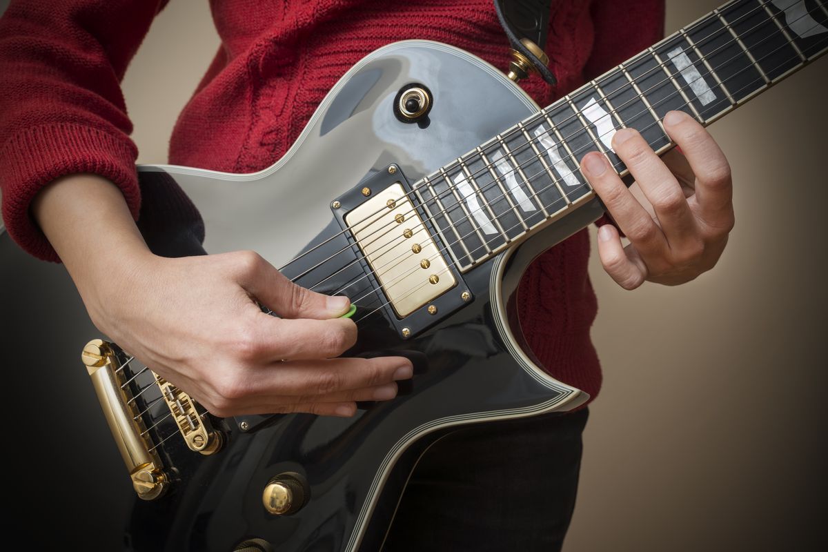 Una donna suona la chitarra elettrica