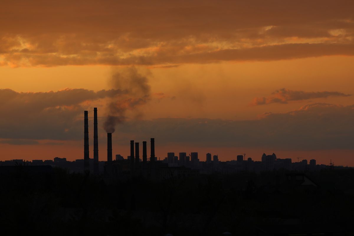 Una ciminiera in città al tramonto