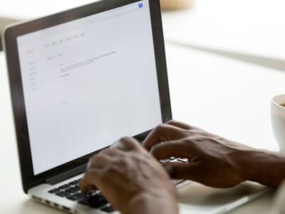 Un uomo al portatile scrive una mail usando Gmail