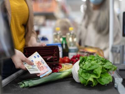 Una donna paga la spesa al supermercato