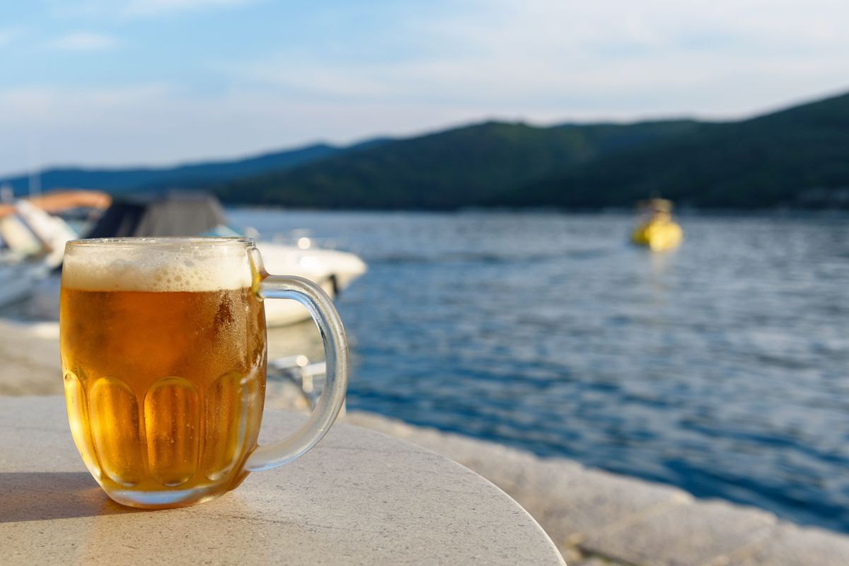Un boccale di birra ghiacciata in riva al mare