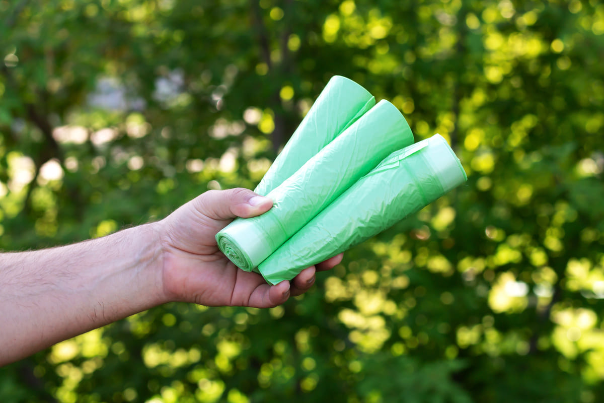 Un uomo porge sacchetti in bioplastica compostabile
