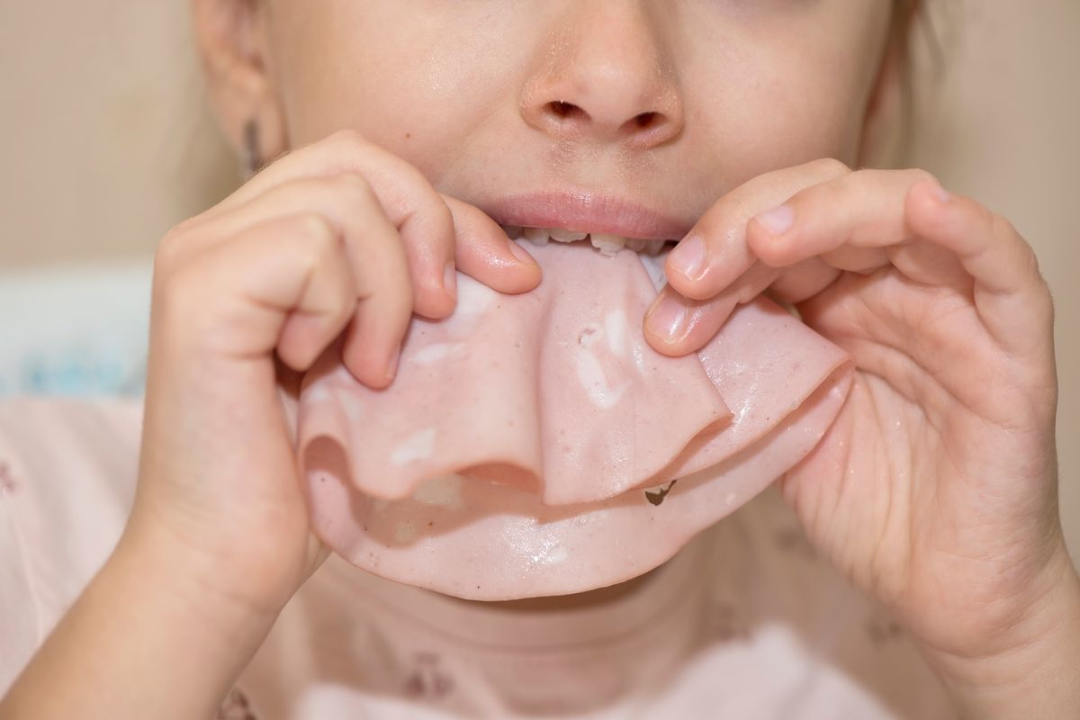 Una bambina mangia la mortadella