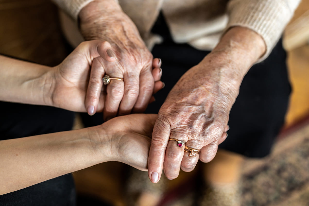 Le mani di un' anziana e quelle di una giovane