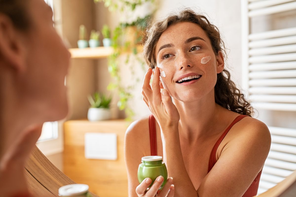 Ragazza applica crema viso