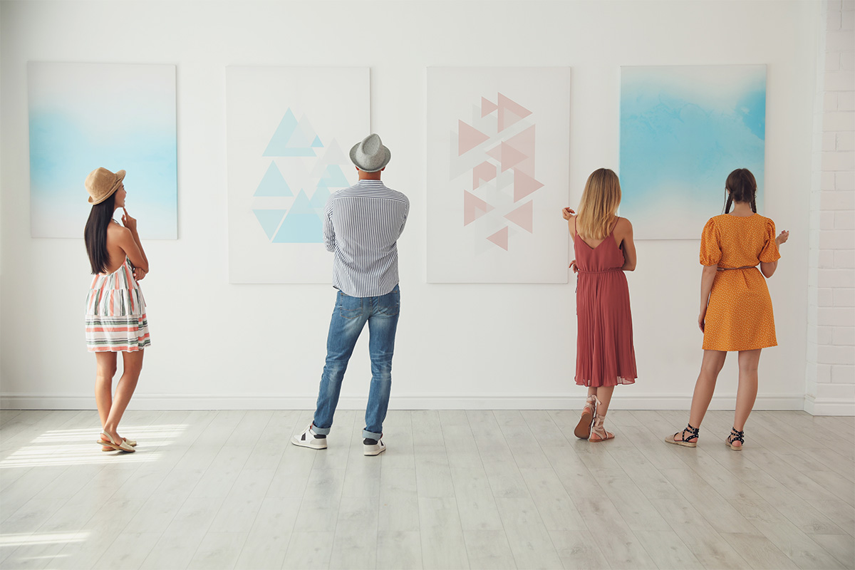 Quattro persone visitano una galleria d'arte contemporanea