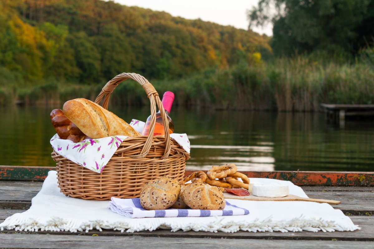 Un cestino di cibo e vino per un picnic all'aperto