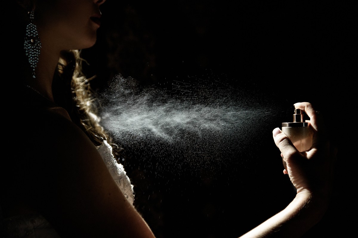 Una donna si spruzza il profumo
