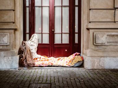 Un senzatetto dorme per strada