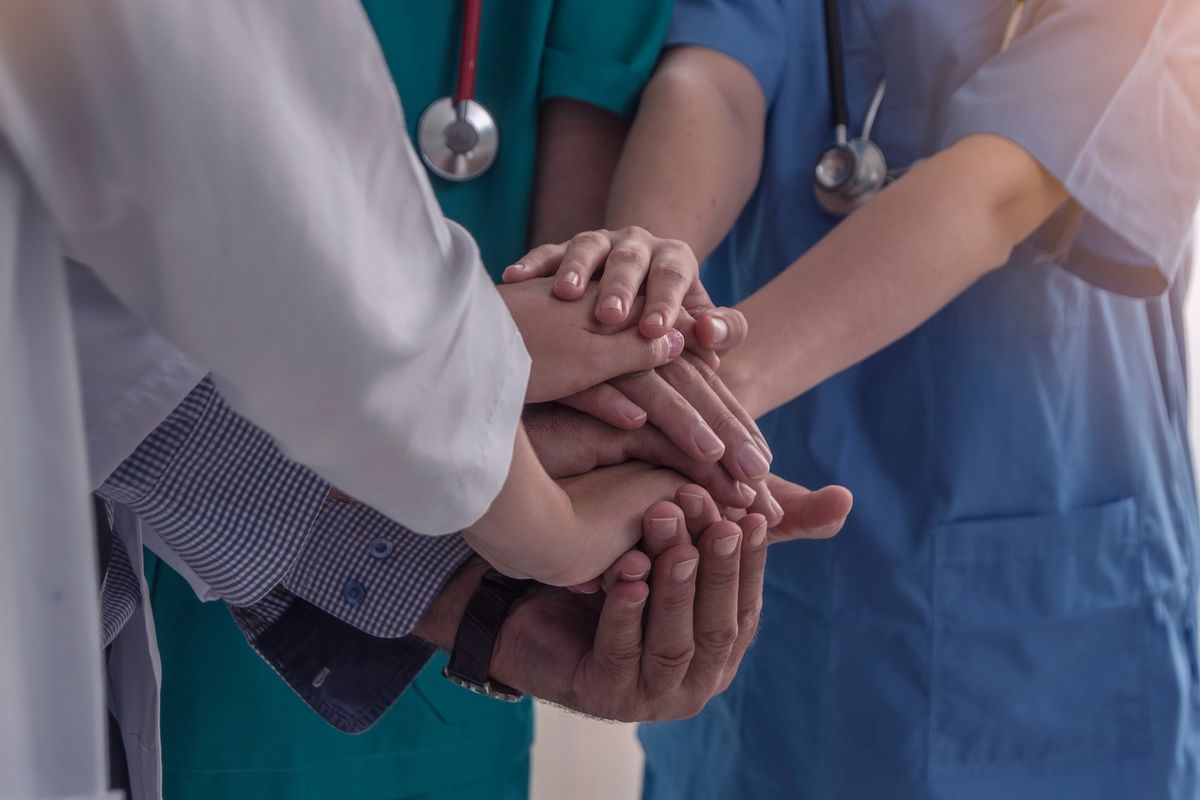 Mani di medici e infermieri che uniscono le forze