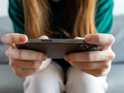 Una ragazza gioca con lo smartphone