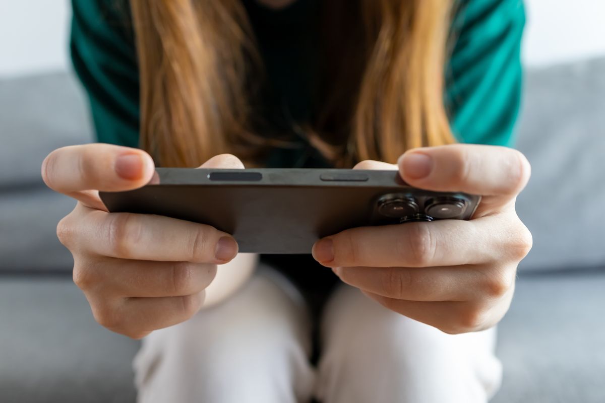 Una ragazza gioca con lo smartphone