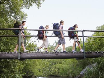 Un gruppo di ragazzi cammina su un ponte in un bosco