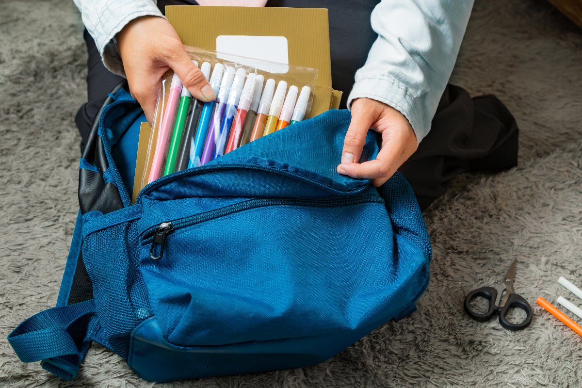 Un bambino prepara lo zaino per andare a scuola