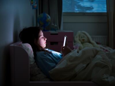 Bambina usa smartphone a letto