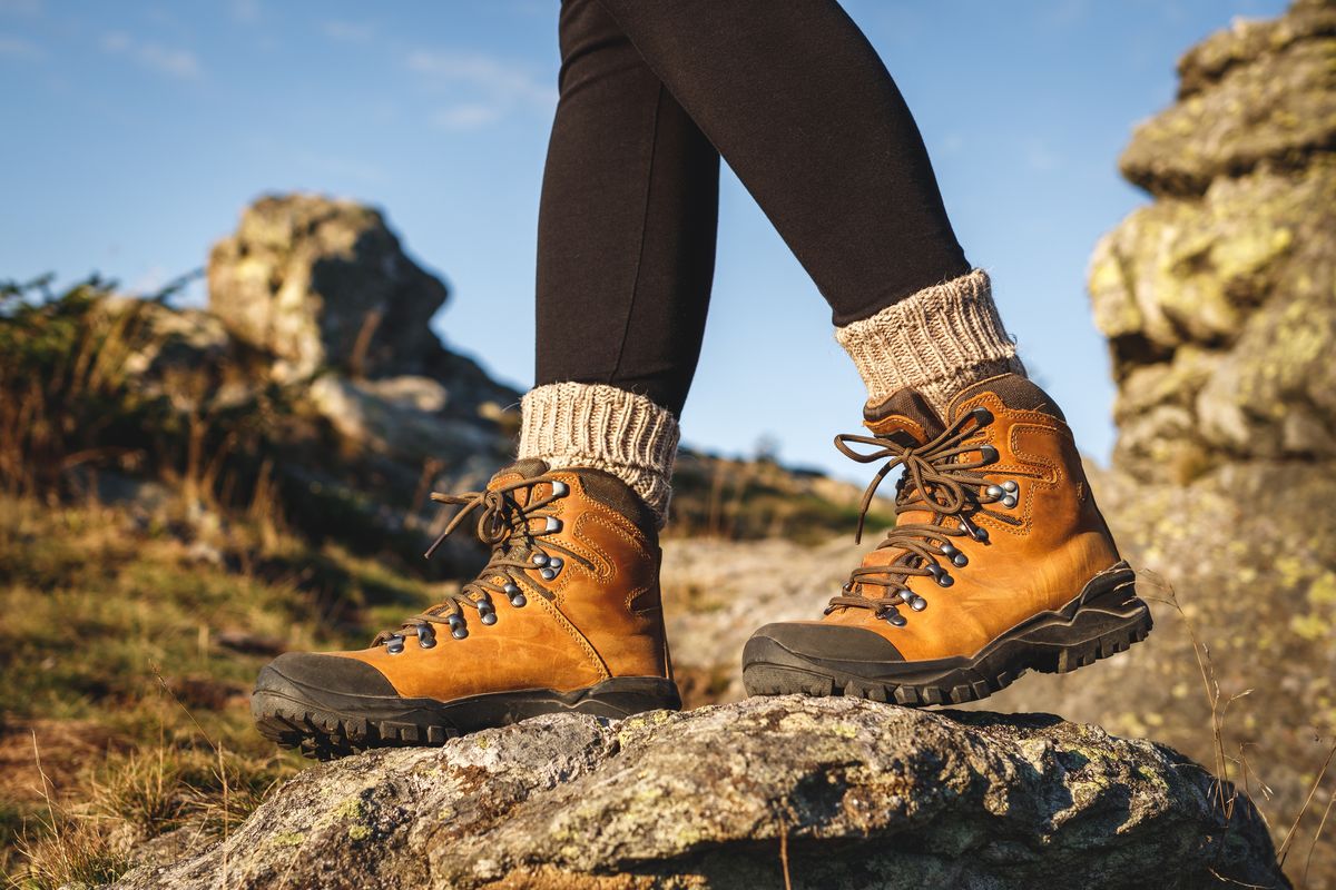 Una donna cammina in montagna con scarpe da trekking